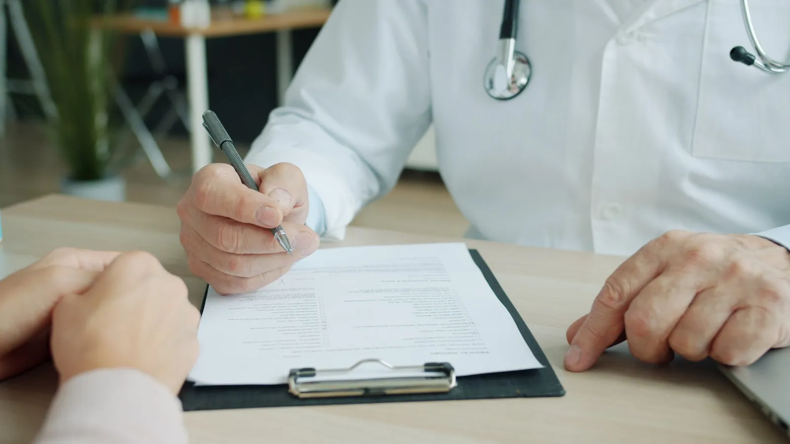 Medic în halat alb completând documentația de conformitate