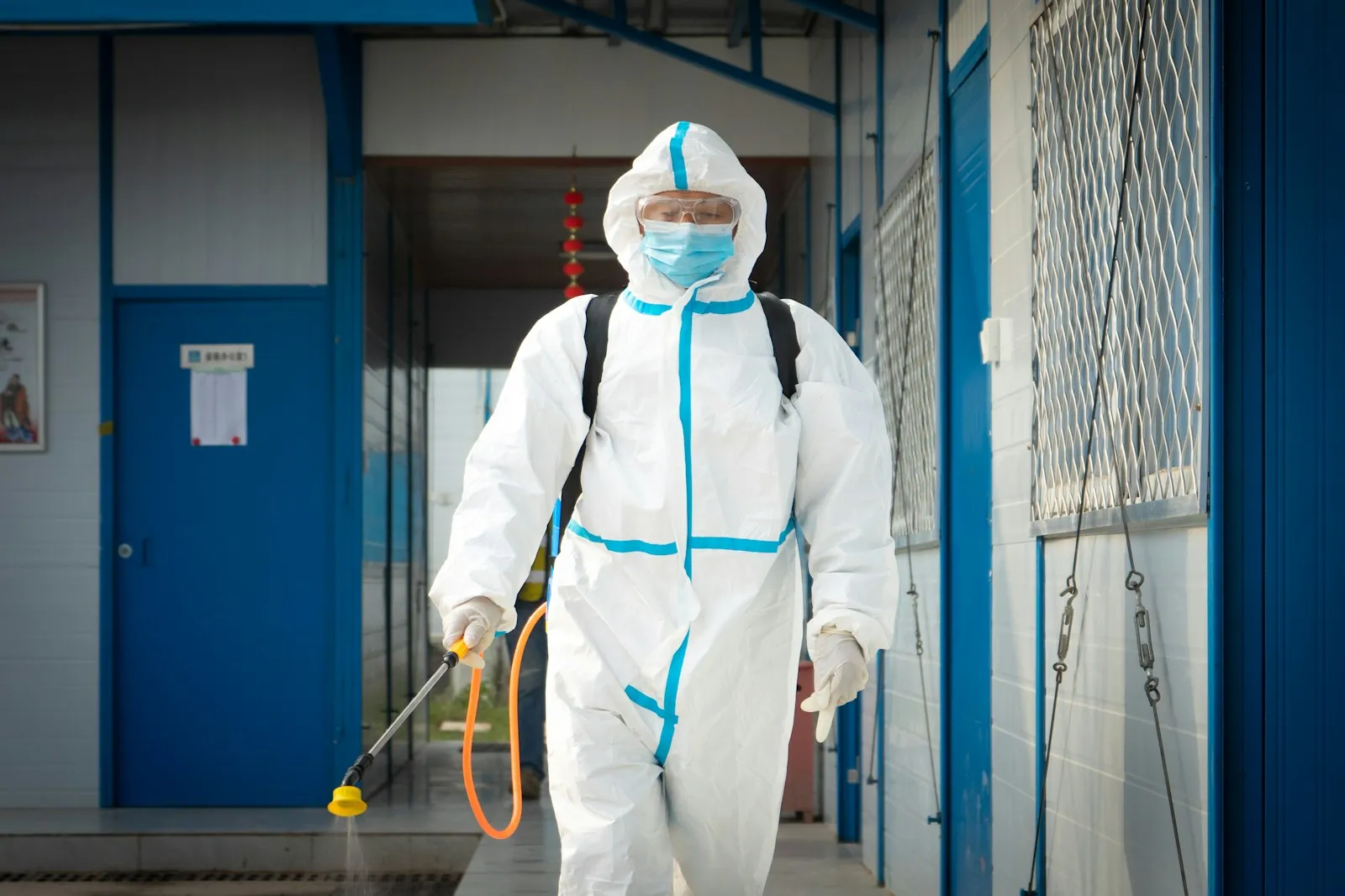 Specialist în echipament complet de protecție, cu pulverizator pentru decontaminare